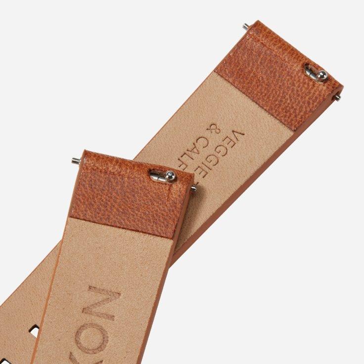 A close-up shot of a brown leather watch strap with "VEGGIE & CALF" embossed on the underside.