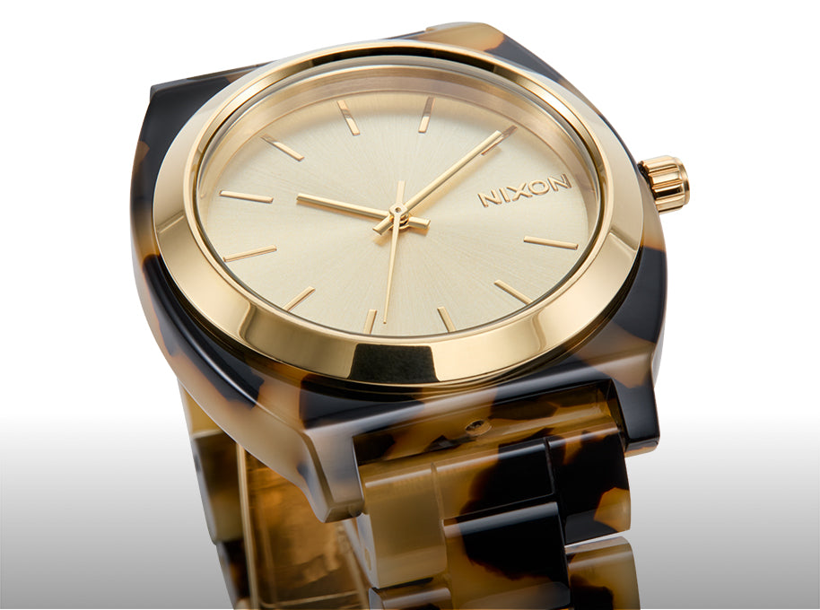 Nixon Time Teller Acetate with gold and tortoiseshell design on a white background